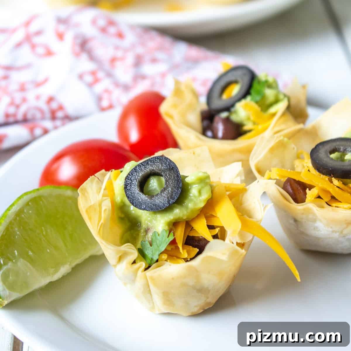 Irresistible Game Day Appetizer Recipes 2 Crispy mini cups filled with black beans, cheese and guacamole and topped with a black olive.