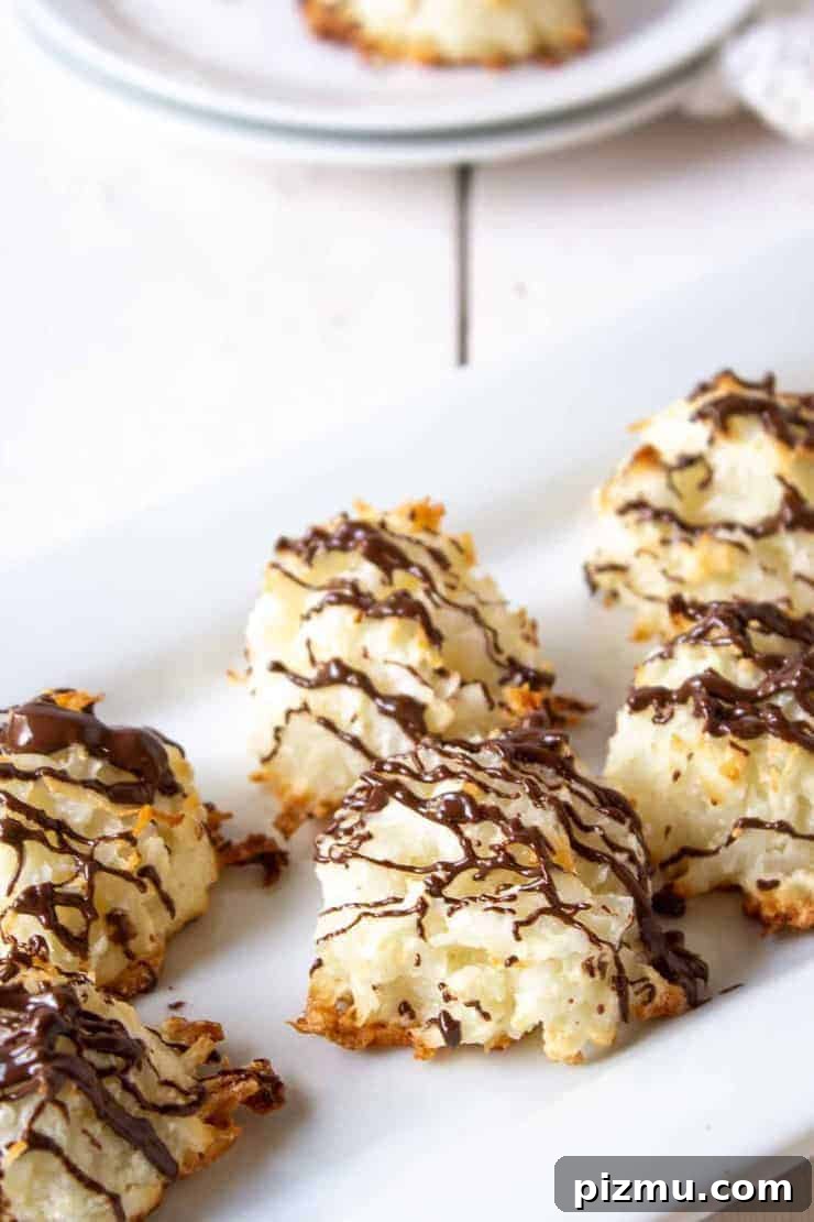 Irresistible Game Day Appetizer Recipes 11 Coconut Macaroons with drizzled chocolate on a white platter.