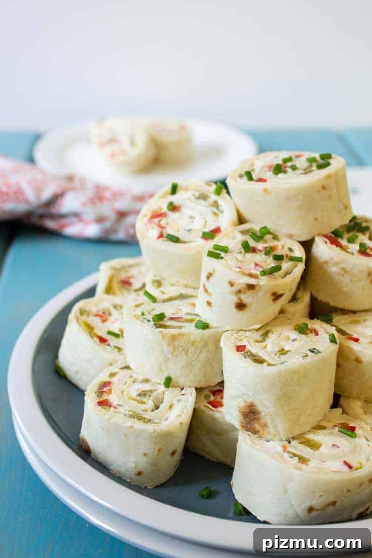 Irresistible Game Day Appetizer Recipes 6 Stack tortilla wraps filled with red peppers and topped with chives.