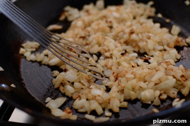 Classic Japanese Hambagu (Hamburger Steak) Recipe 3 Chopped onion is caramelizing in a skillet.