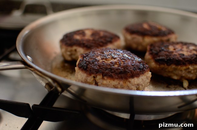 Classic Japanese Hambagu (Hamburger Steak) Recipe 6 Hamburger steak patties are browning in a skillet.