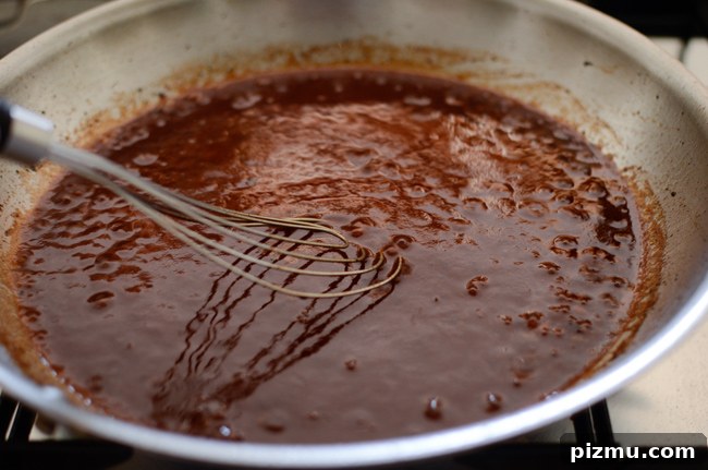 Classic Japanese Hambagu (Hamburger Steak) Recipe 9 Red wind reduction sauce is made in a skillet for Japanese hamburger steak recipe.