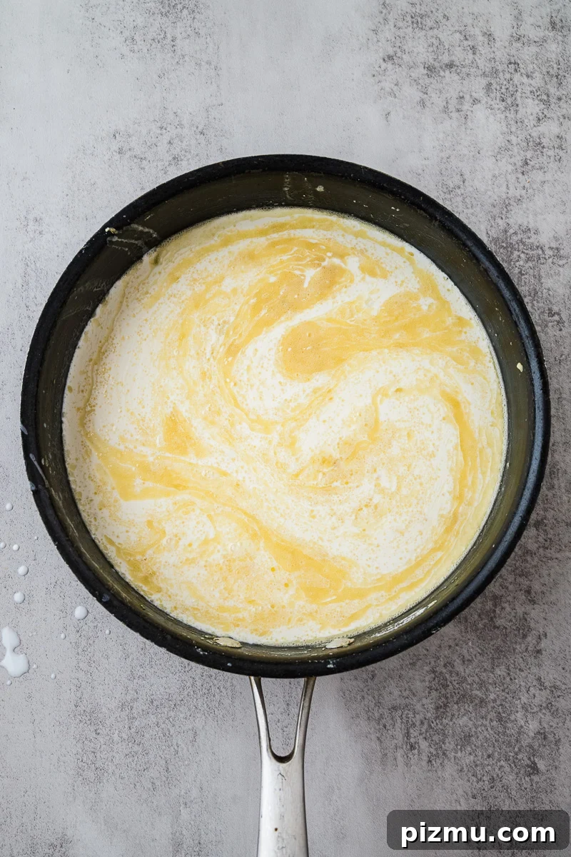 Creamy Chicken Alfredo Lasagna with Ricotta Recipe 9 Cream is added to skillet.