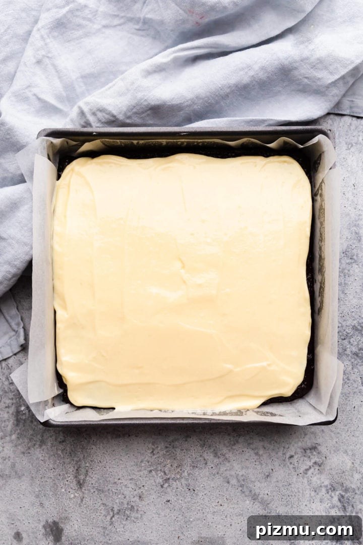Cheesecake Swirl Brownies with Cream Cheese Filling 7 top view of baking tin with cheesecake layer batter on top of the brownie batter