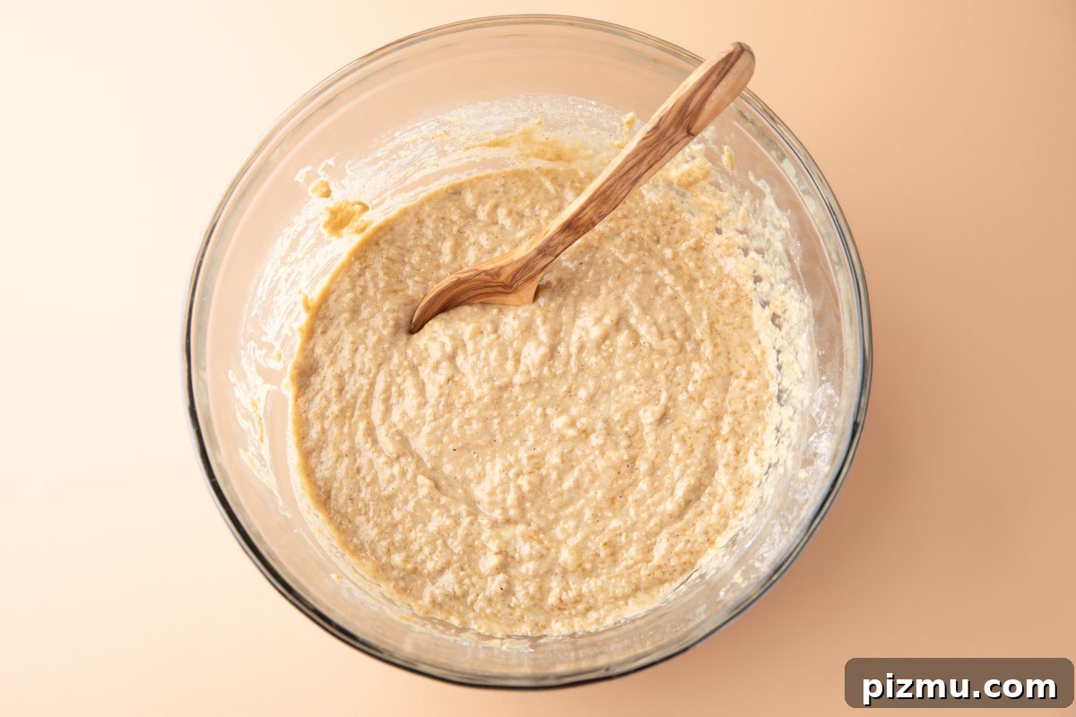 Moist Banana Oatmeal Muffins with Cinnamon 3 banana oatmeal muffin batter mixed together in a glass mixing bowl