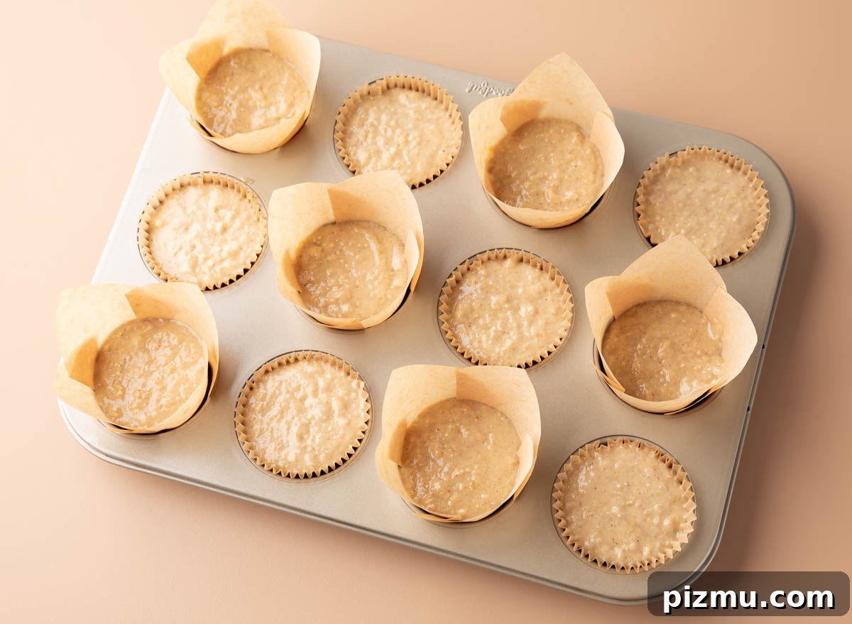 Moist Banana Oatmeal Muffins with Cinnamon 4 muffin batter in lined muffin cups in a nonstick muffin tin
