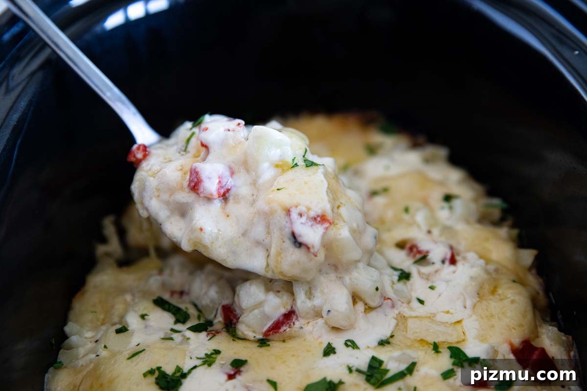 Slow Cooker Cheesy Potatoes 5 spoonful of cooked potatoes in a slow cooker.