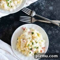 plates with crockpot cheesy potatoes and forks.