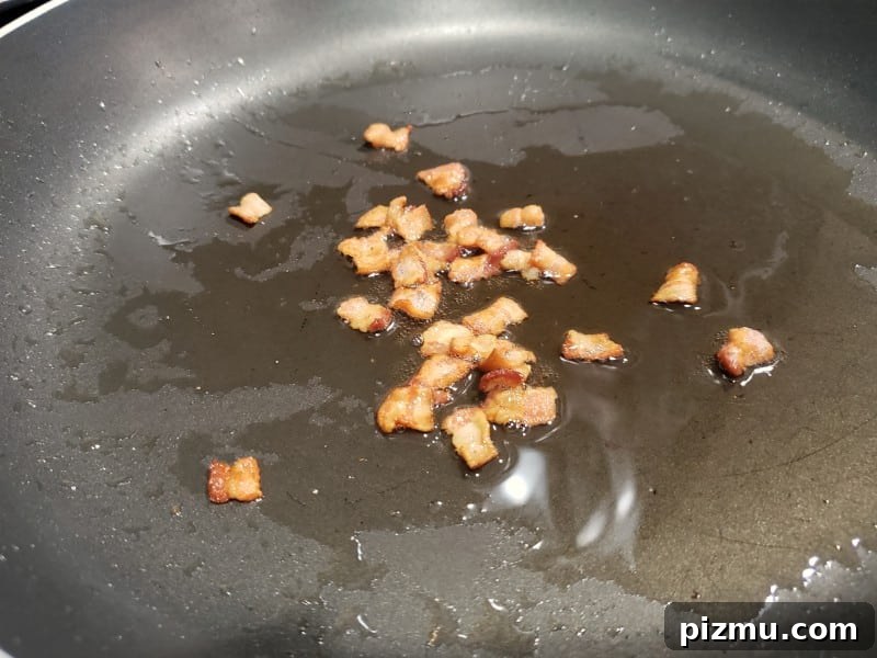 Seared Scallops with Garlic Butter Spinach 6 bacon crumbles cooking in a skillet