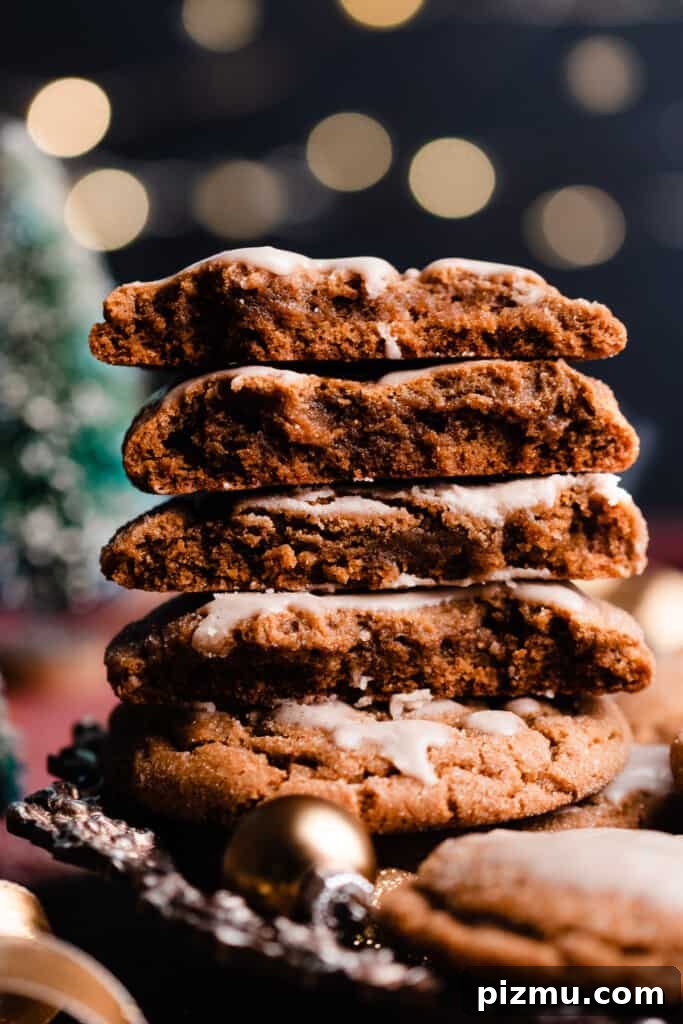 A stack of molasses cookie halves with twinkling lights in the background.