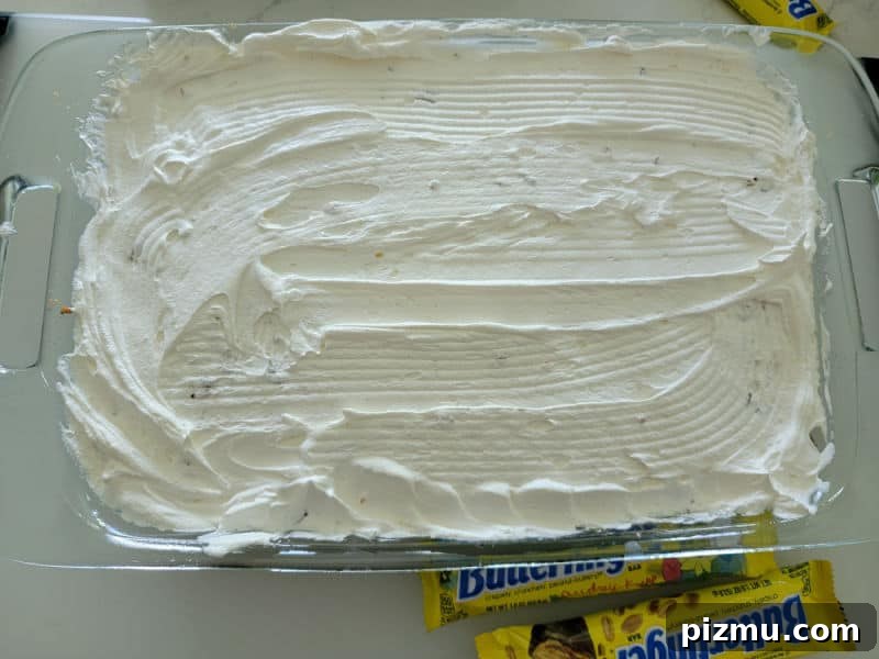 Butterfinger Cake Recipe with Chocolate Peanut Butter Crunch 7 Cool whip spread over a chocolate poke cake for Butterfinger cake