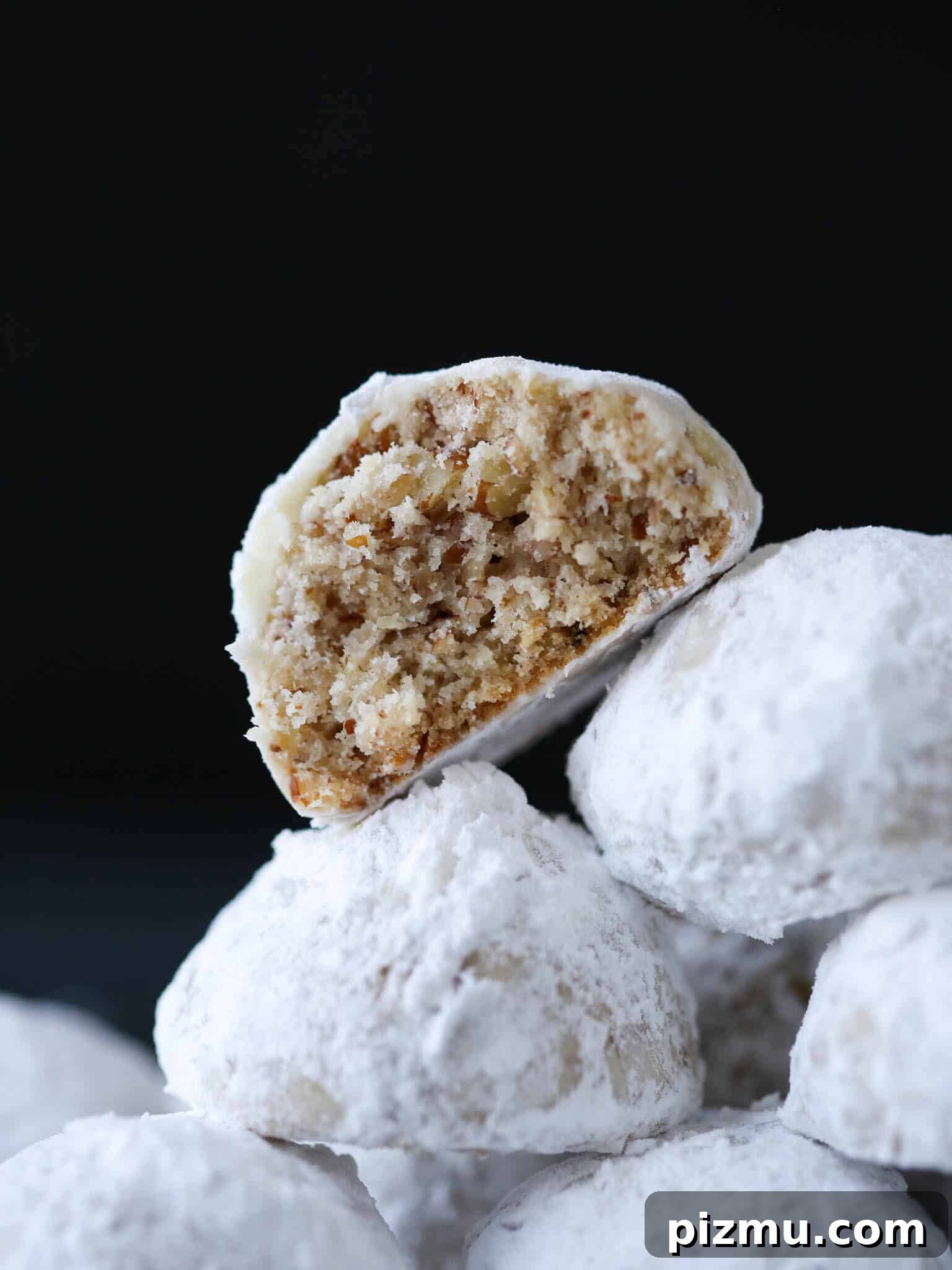 20 Classic Christmas Cookie Recipes to Bake This Season 22 Pecan Snowball Cookies stacked cut open.