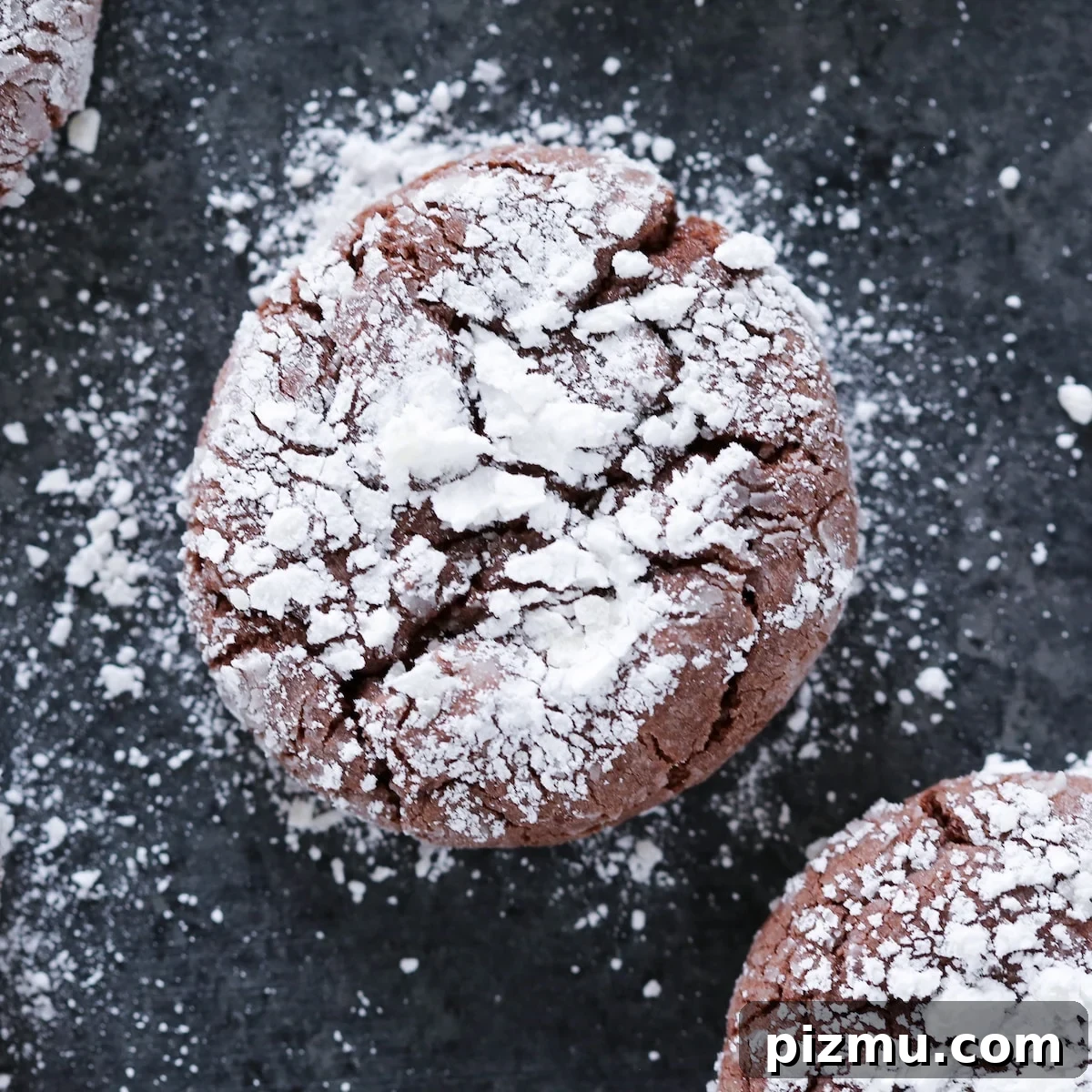 20 Classic Christmas Cookie Recipes to Bake This Season 5 Chocolate Crackle Cookie with powdered sugar on black surface Easy Chocolate Desserts.