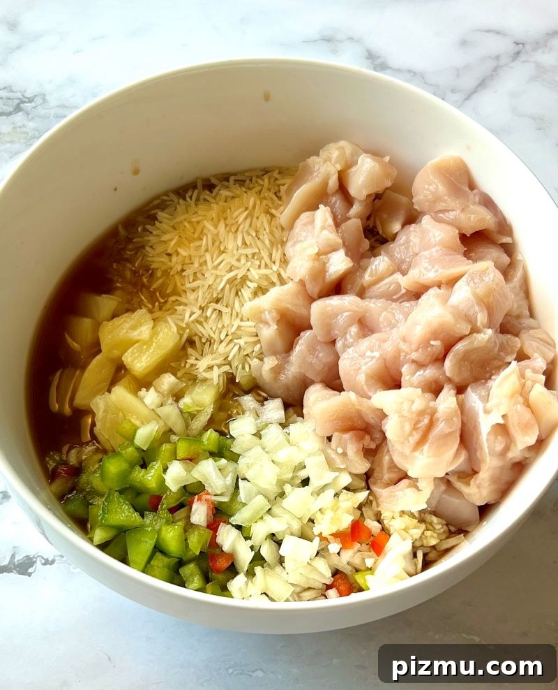 Pineapple Chicken and Rice Casserole Recipe 4 Chicken, pineapple, veggies, rice, and sauce in a bowl.