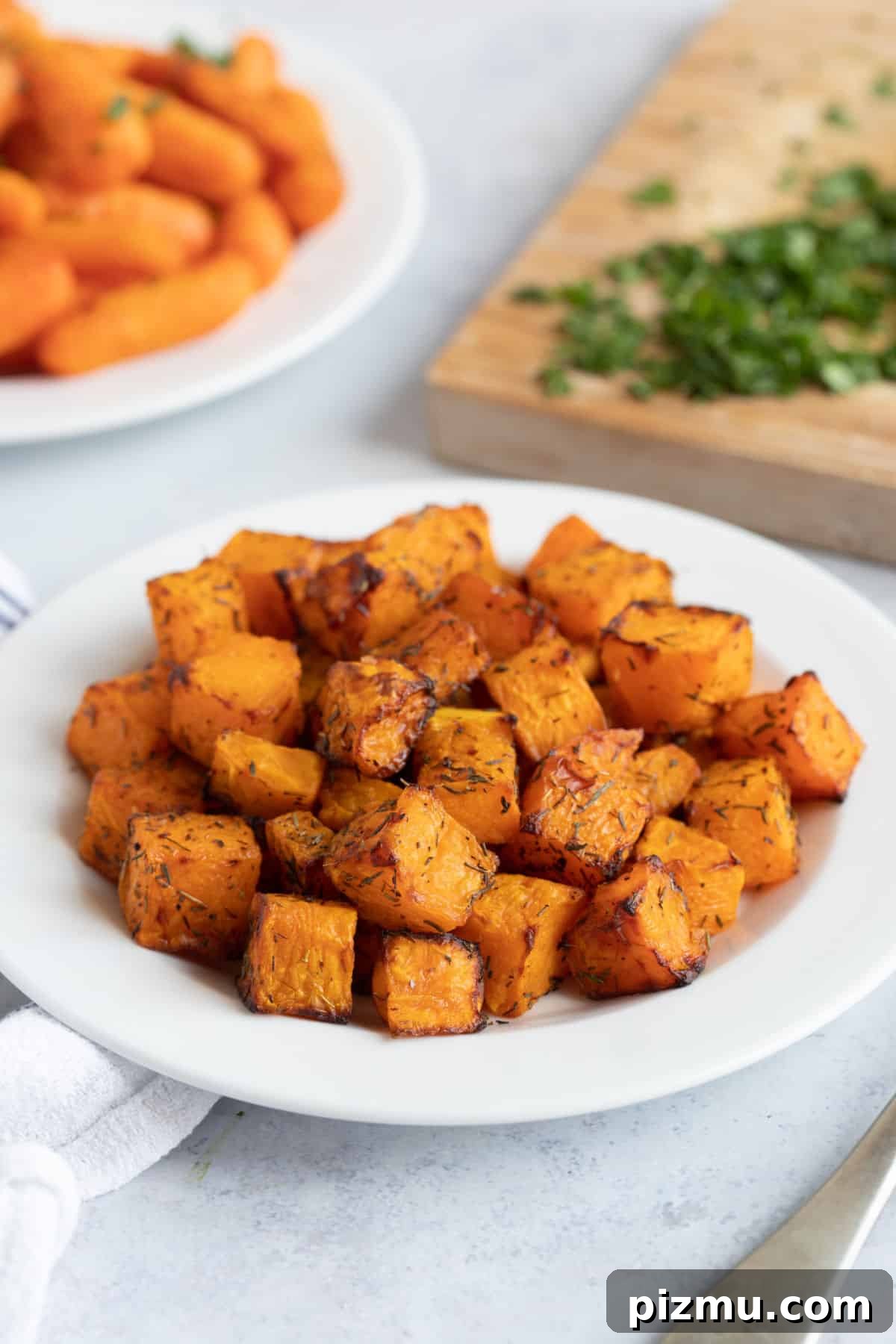 Crispy Air Fryer Butternut Squash with Garlic and Herbs 7 Air fryer butternut squash on a white plate.