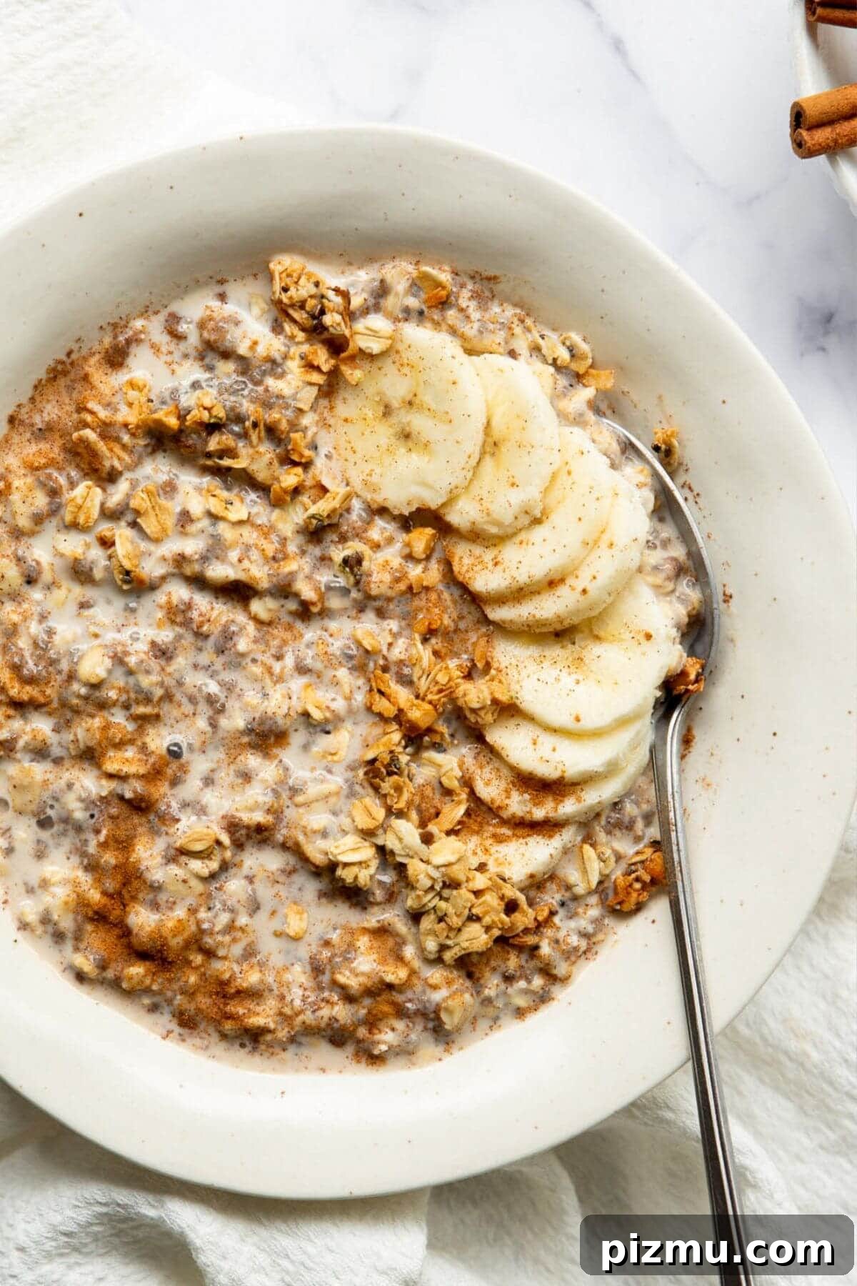 Creamy Cinnamon Overnight Oats for Make-Ahead Breakfast 2 Healthy cinnamon overnight oats in a bowl topped with banana slices and granola.