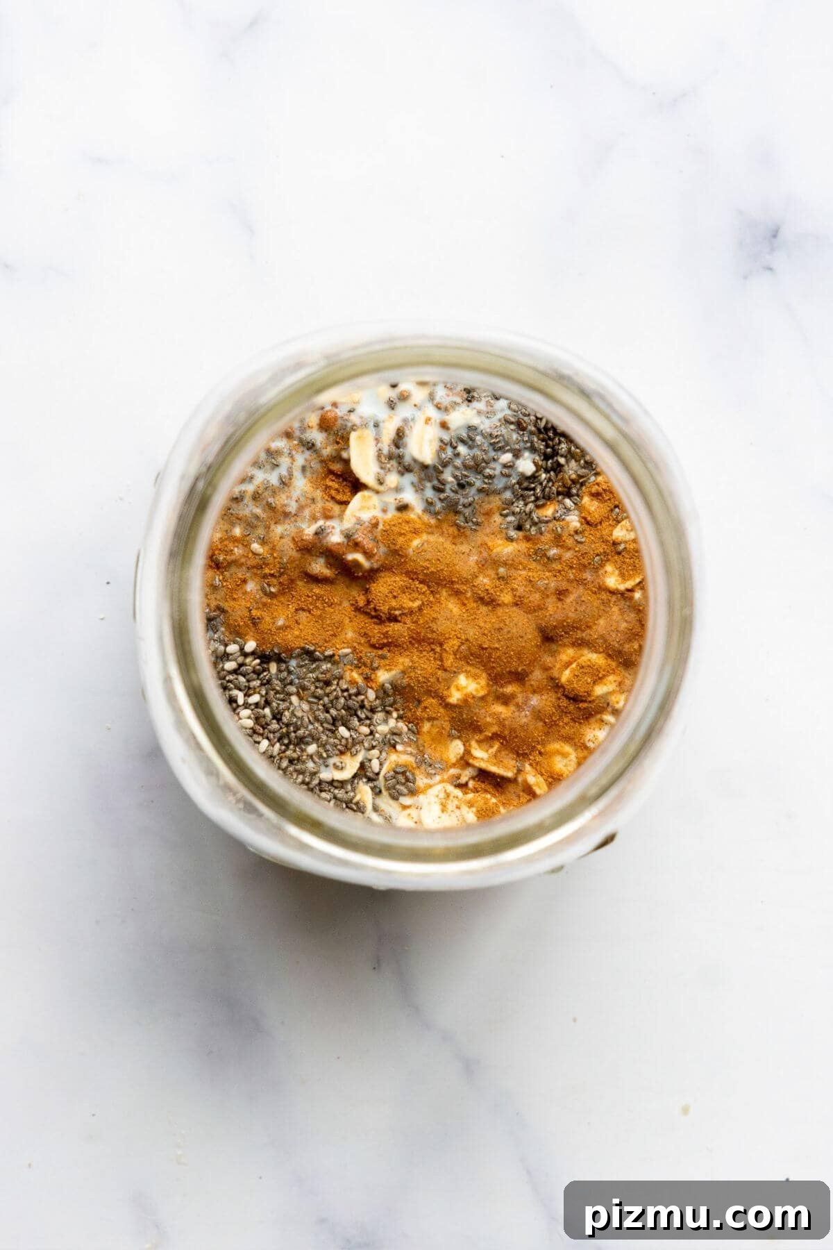Creamy Cinnamon Overnight Oats for Make-Ahead Breakfast 4 Cinnamon and chia seeds layered over oats and milk in a glass jar.