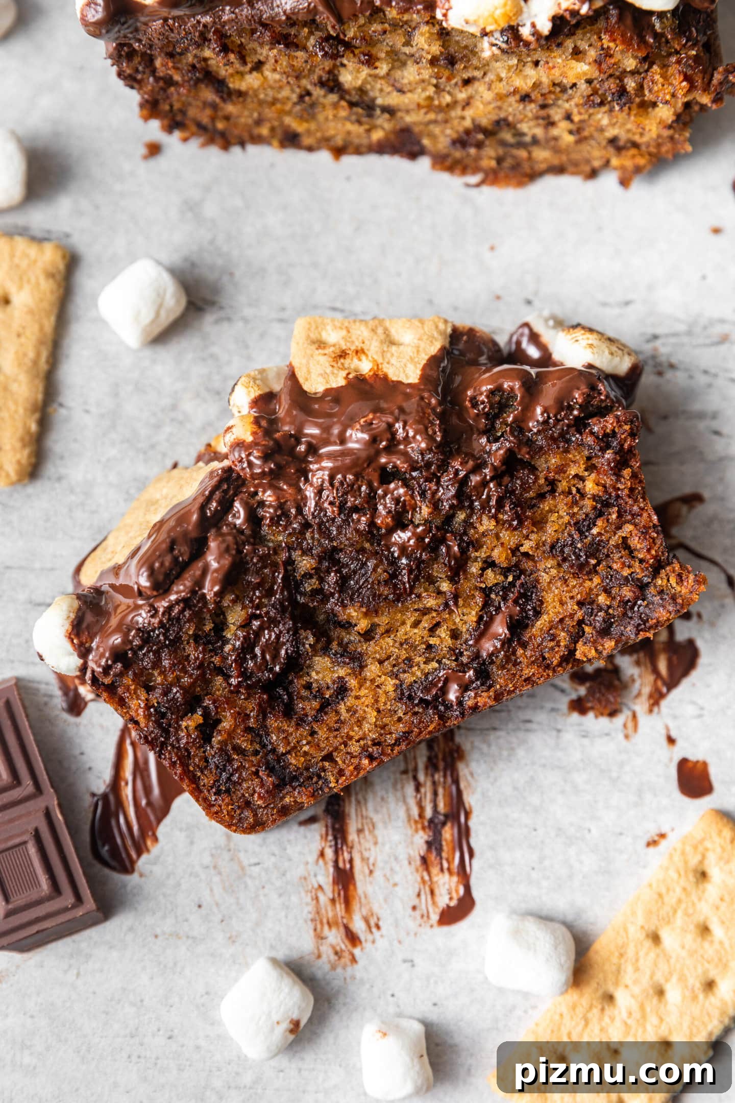 A close up on a slice of S'mores Banana Bread with melted chocolate chunks inside