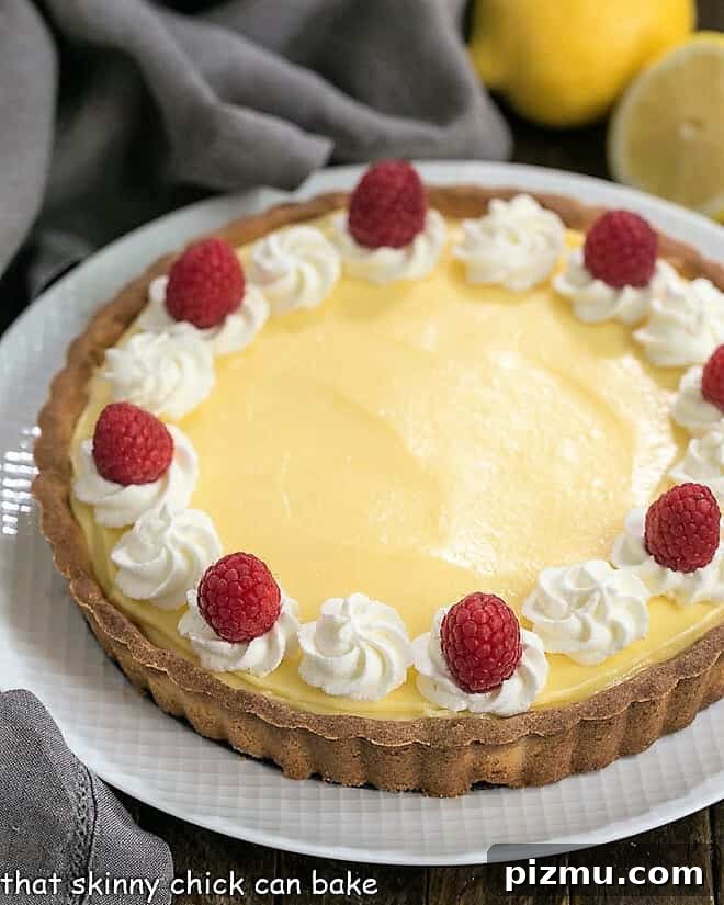 Close view of Creamy Lemon Tart on a white serving dish.