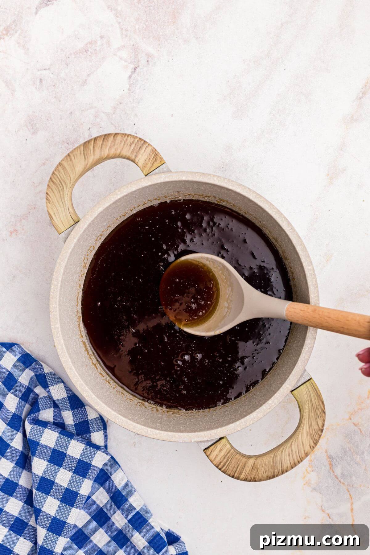 Sugars dissolved into water with maple extract in a medium saucepan making homemade syrup.