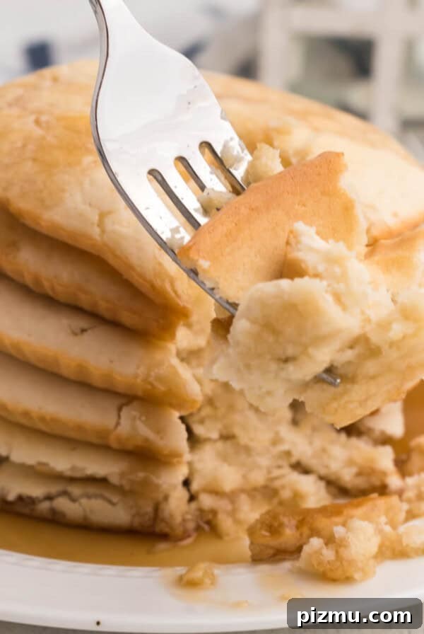 Air fried pancakes stacked on a plate, topped with syrup, and a bite shot of the pancakes on a fork.