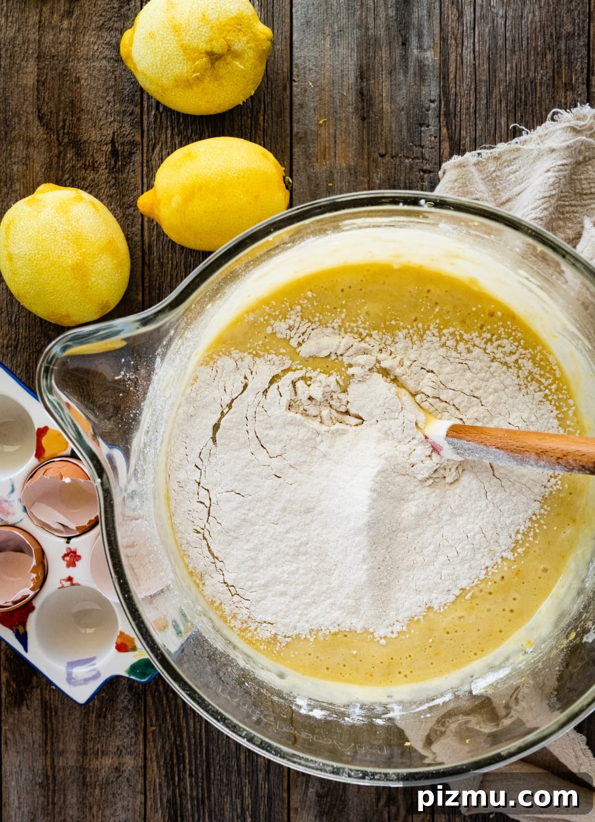 How to make olive oil cake (step-by-step) instructions- mixing wet and dry ingredients with wooden spoon.
