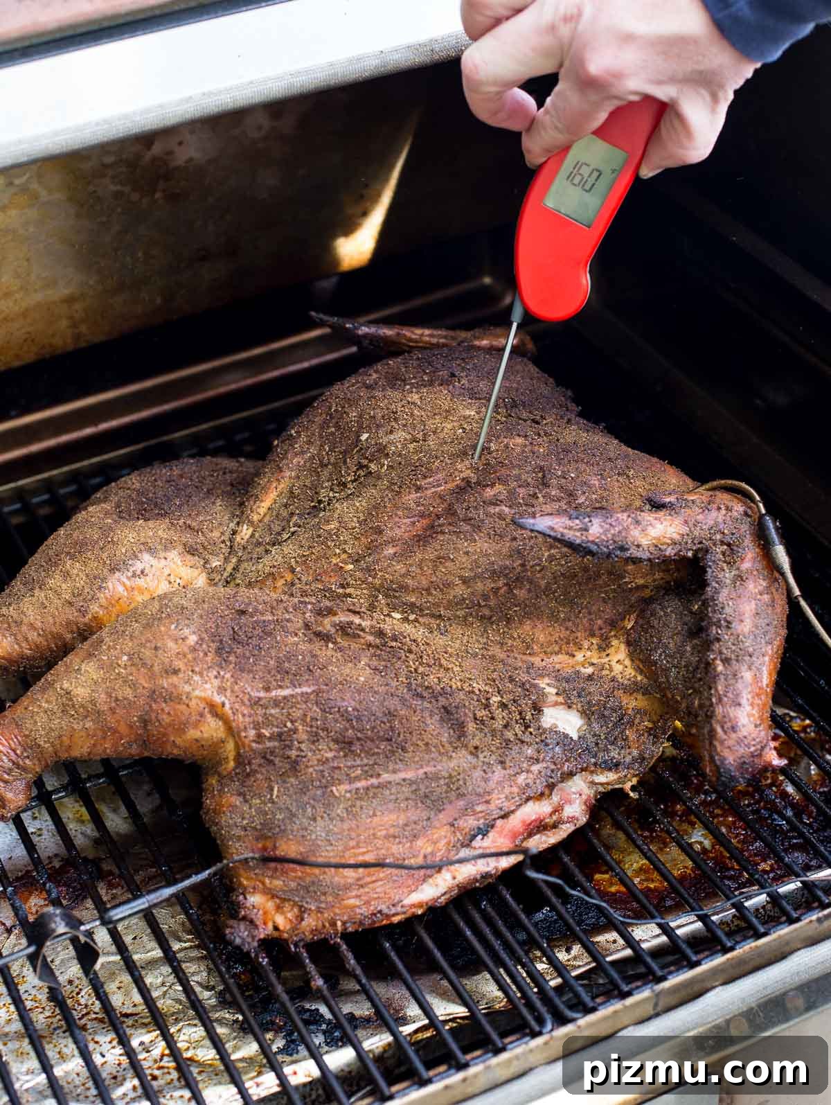 Taking the temperautre of a spatchcocked turkey with the Thermapen One on a pellet grill.
