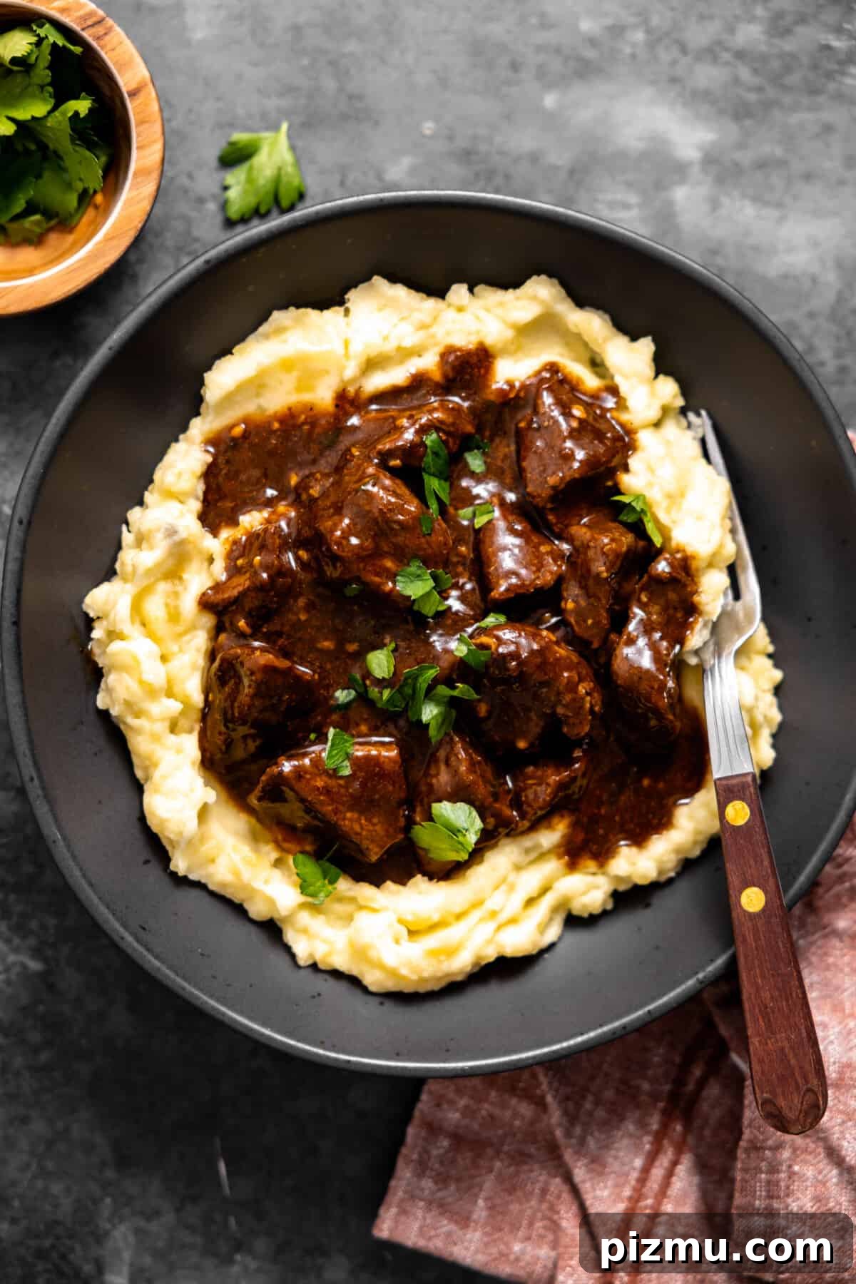 Bowl with mashed potatoes topped with beef tips and gravy.