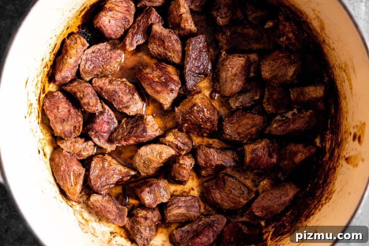 Beef tips searing in a skillet.