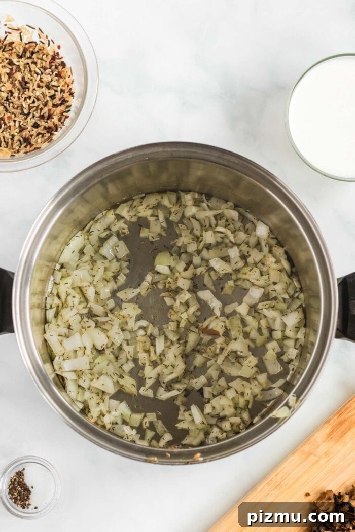 Creamy Vegan Mushroom and Wild Rice Soup 7 Diced onions cooking in herbs in a soup pot.