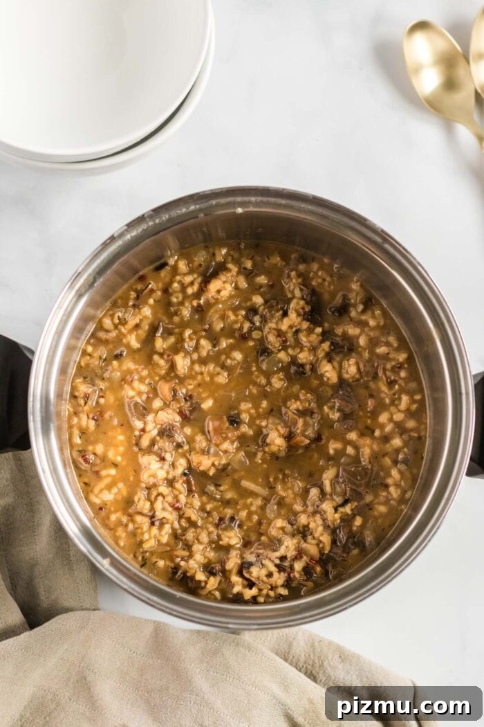 Creamy Vegan Mushroom and Wild Rice Soup 8 A thick mushroom wild rice soup in a soup pot.