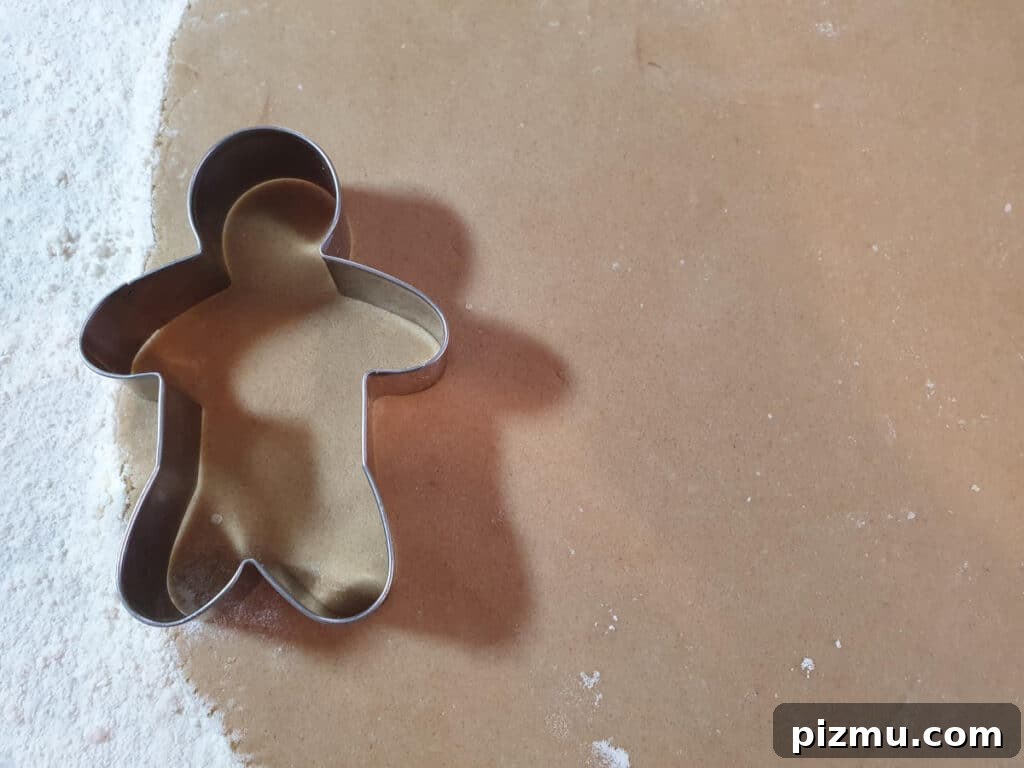 Cutting gingerbread men shapes out of rolled dough