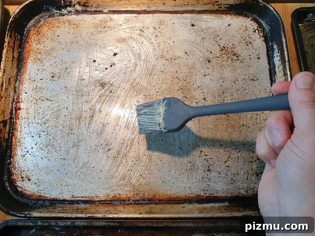 Greasing trays with a pastry brush and butter