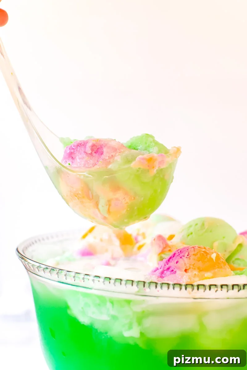 A ladle scooping green punch out of a bowl.