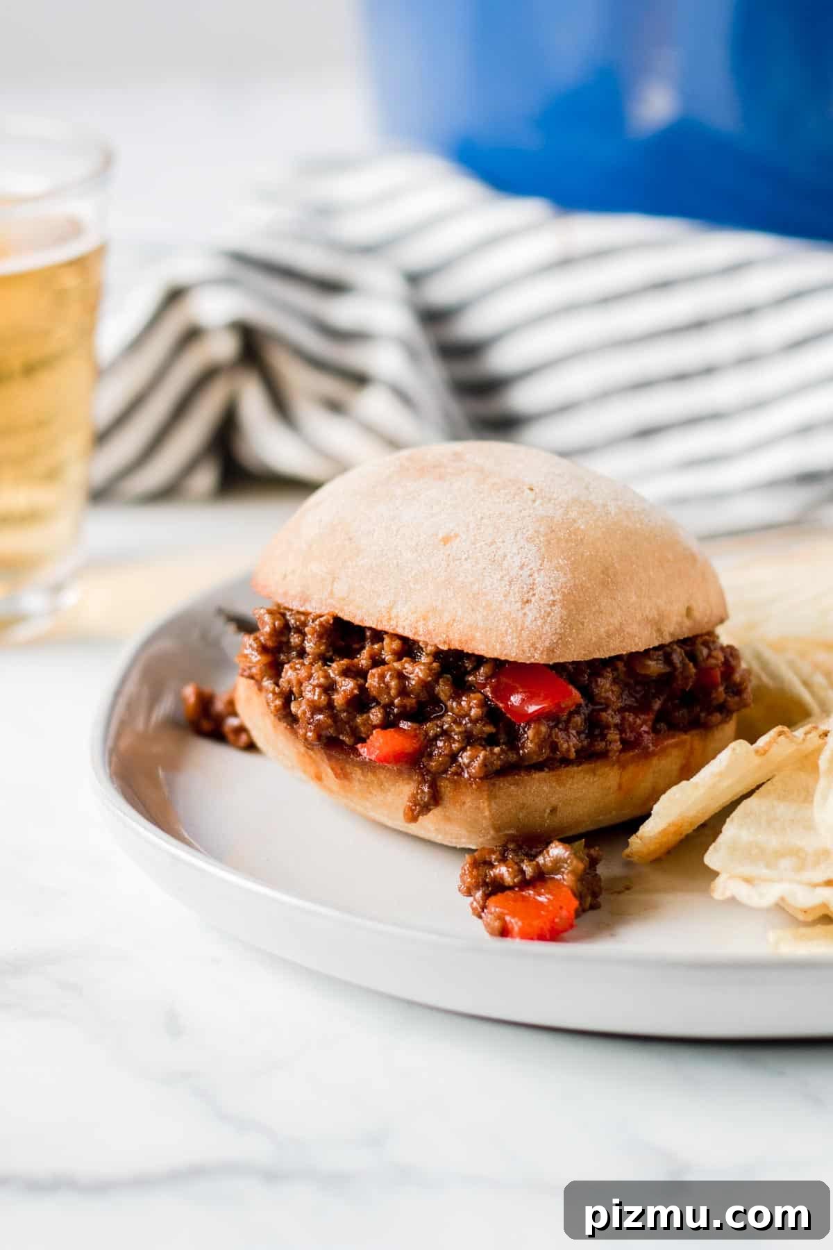 Homemade Gluten-Free Sloppy Joes 2 Sloppy Joe sandwich in front of blue pot and striped towel.