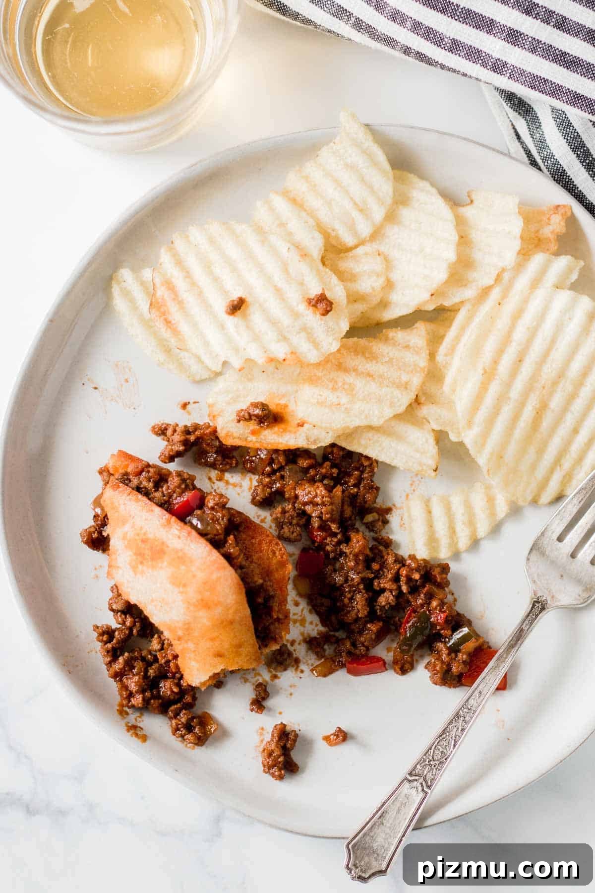 Homemade Gluten-Free Sloppy Joes 6 Mostly eaten sloppy Joe on a plate next to ruffle potato chips.