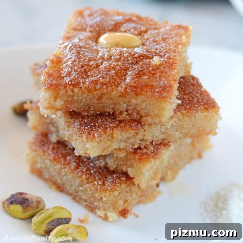 Basbousa: Classic Middle Eastern Semolina Cake with Syrup 2 basbousa squares stacked on top of each other on a white plate