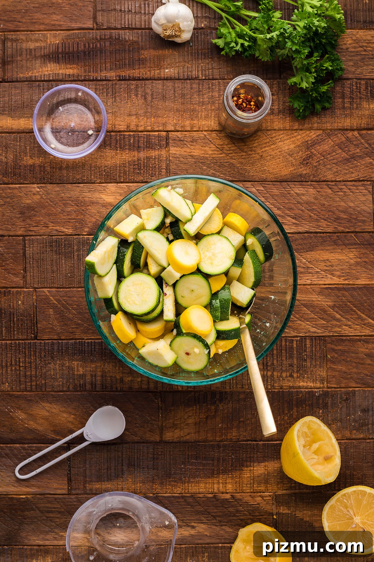 Creamy Lemon Chicken Pasta in the Instant Pot 15 Glass bowl with sliced zucchini and squash, perfect for preparing a fresh Pasta with Zucchini and Squash, surrounded by parsley, garlic, seasonings, and lemon on a wooden table.