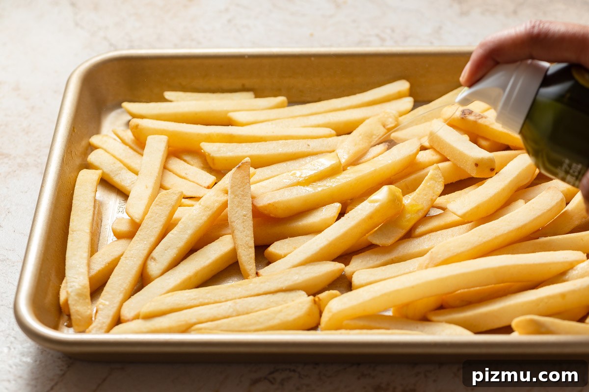 spraying frozen french fries with oil