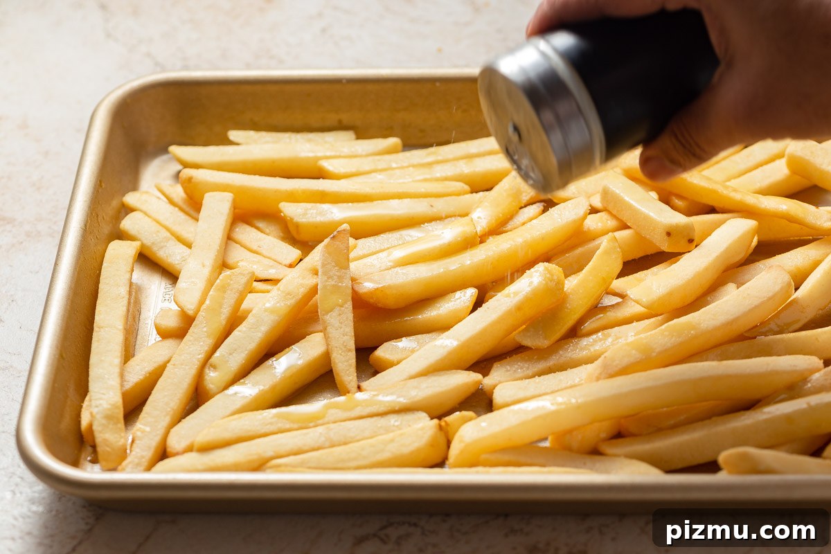 seasoning the frozen french fries with salt