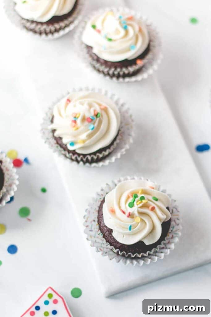 Celiac Disease: Lessons From My First Two Years 3 Gluten-free chocolate cupcakes with vanilla frosting and rainbow sprinkles on a marble platter.
