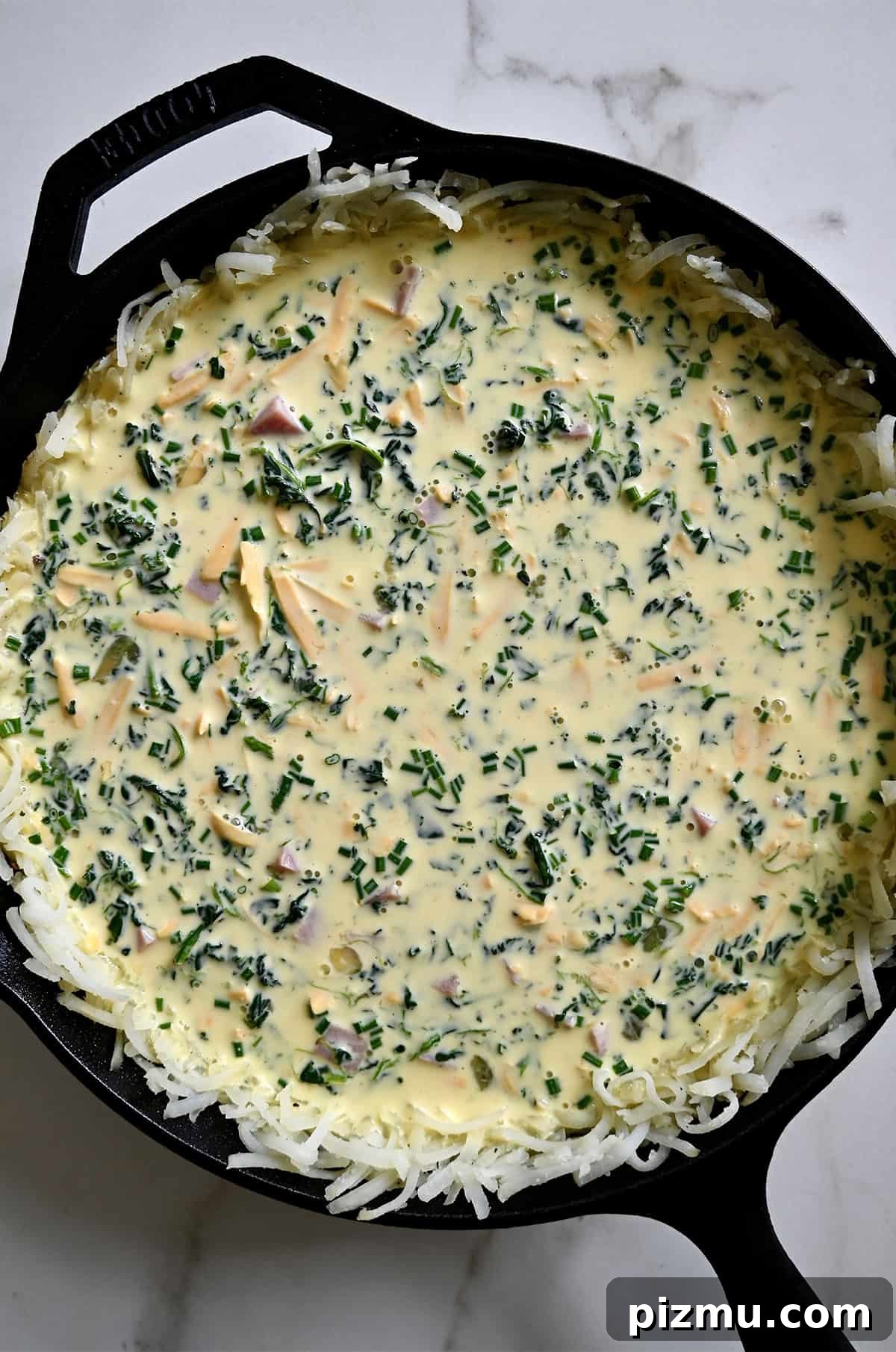 Ham and Cheese Quiche with Crispy Hash Brown Crust 9 Unbaked potato crusted quiche in a cast iron skillet.