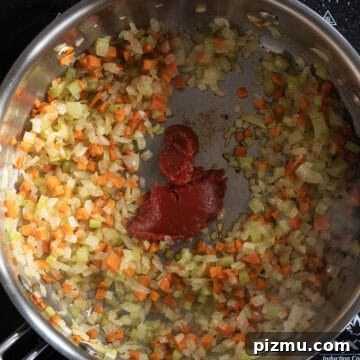 Classic Italian Lentils with Garlic and Rosemary 5 Tomato paste caramelizing in a saucepan.