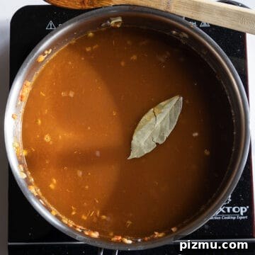 Classic Italian Lentils with Garlic and Rosemary 7 Chicken broth and bay leaf added to the saucepan.