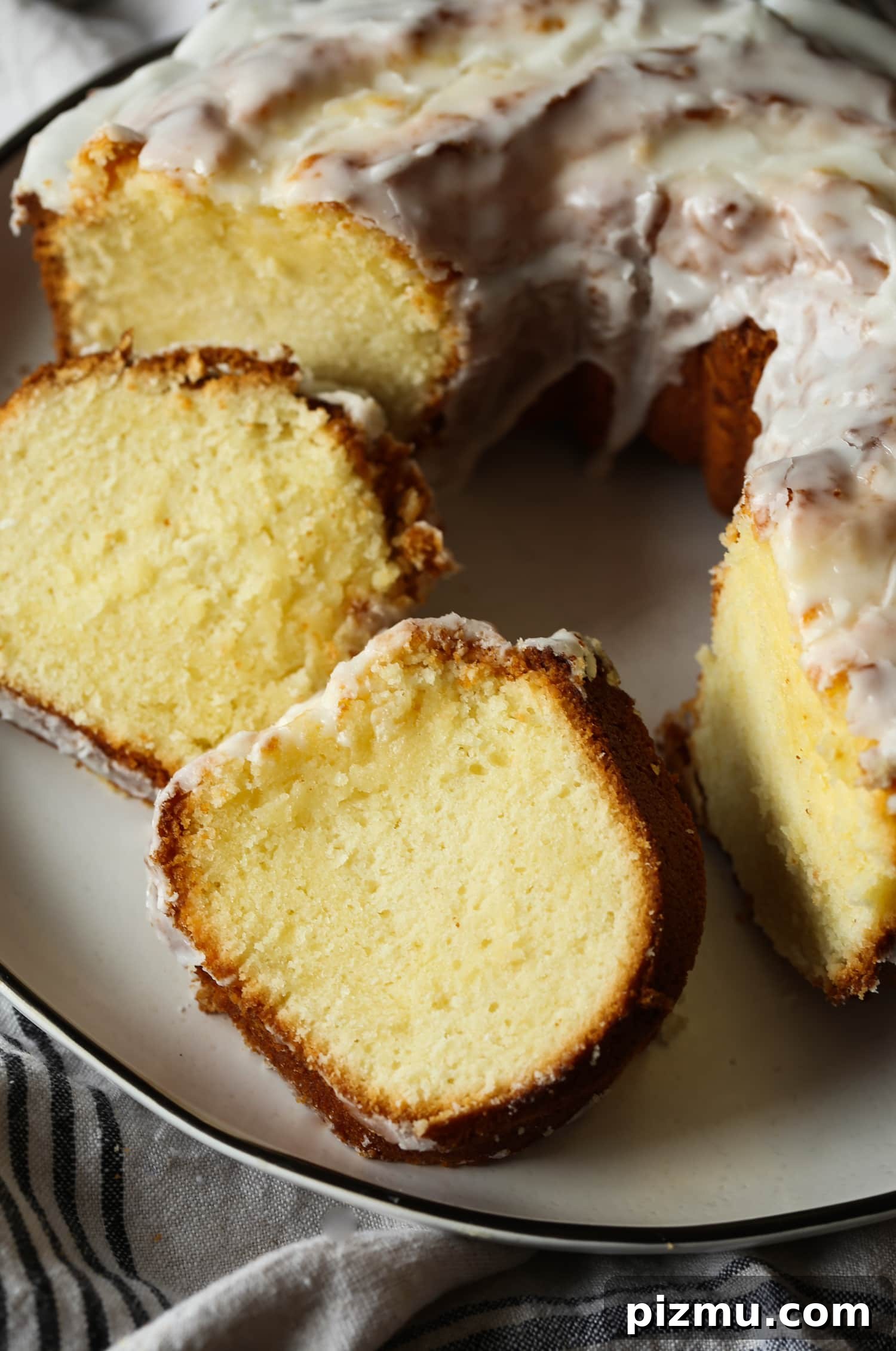 A deliciously simple, classic 7UP Cake tastes like a lemon pound cake with tons of old fashioned charm! Close up of cake slices next to a 7UP bundt cake on a plate.