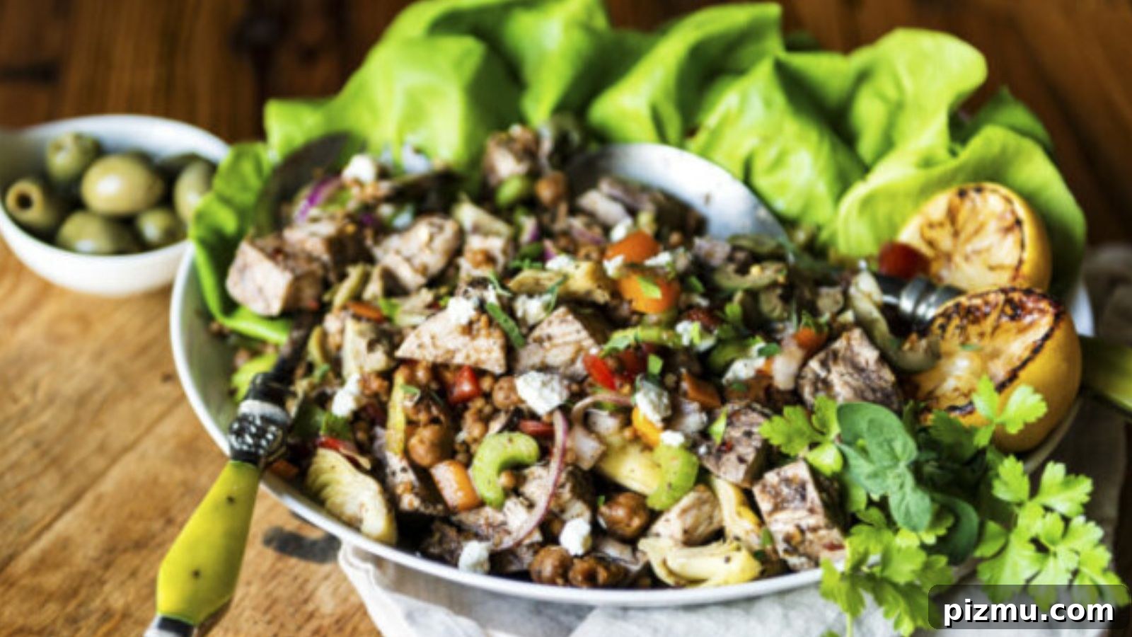 Salad topped with grilled chicken and Mediterranean vegetables with vinaigrette drizzle.