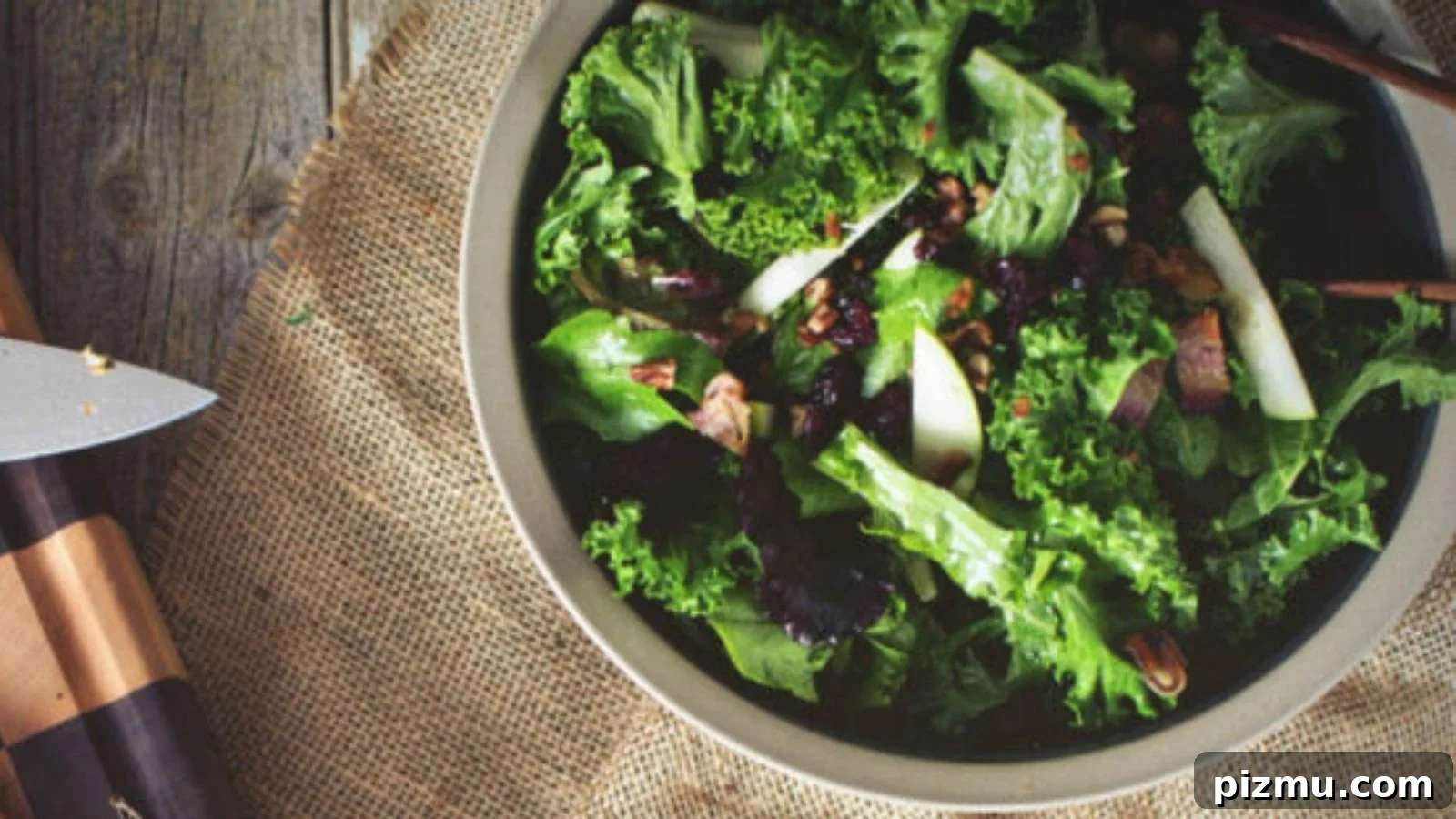 Salad with kale, apples, and warm bacon vinaigrette tossed lightly.