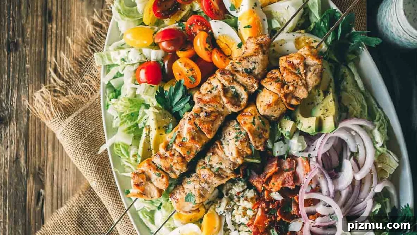 Grilled chicken Cobb salad stacked with grilled chicken, bacon, eggs, avocado, and crisp greens.