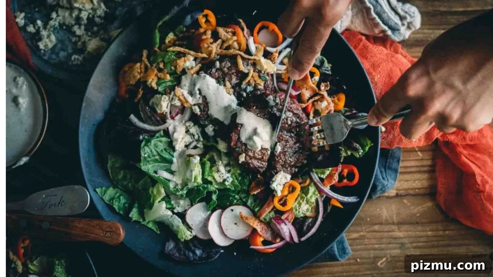 Hamburger salad topped with seared beef and keto blue cheese dressing.
