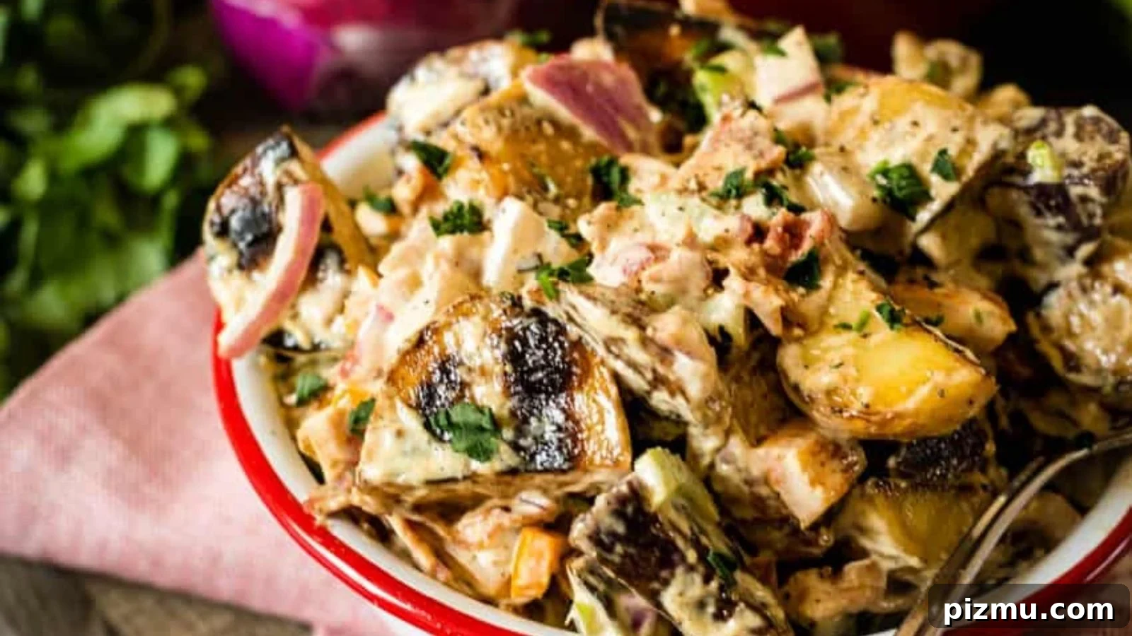 Potato salad mixed with smoked potatoes and creamy dressing throughout.